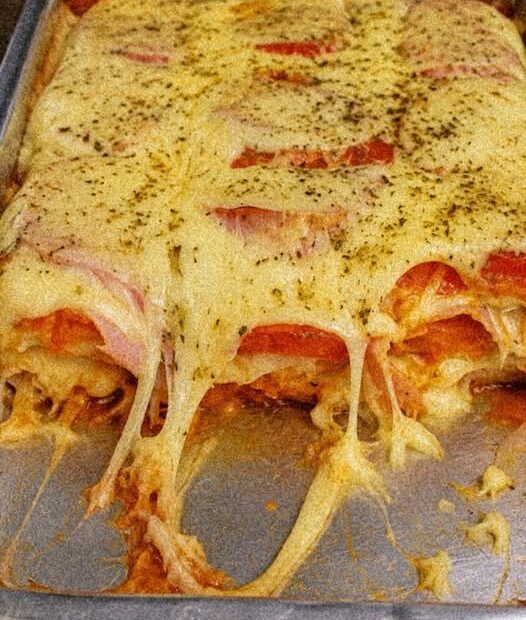 Queijo, presunto e massa em camadas que ficam cremosas e douradas